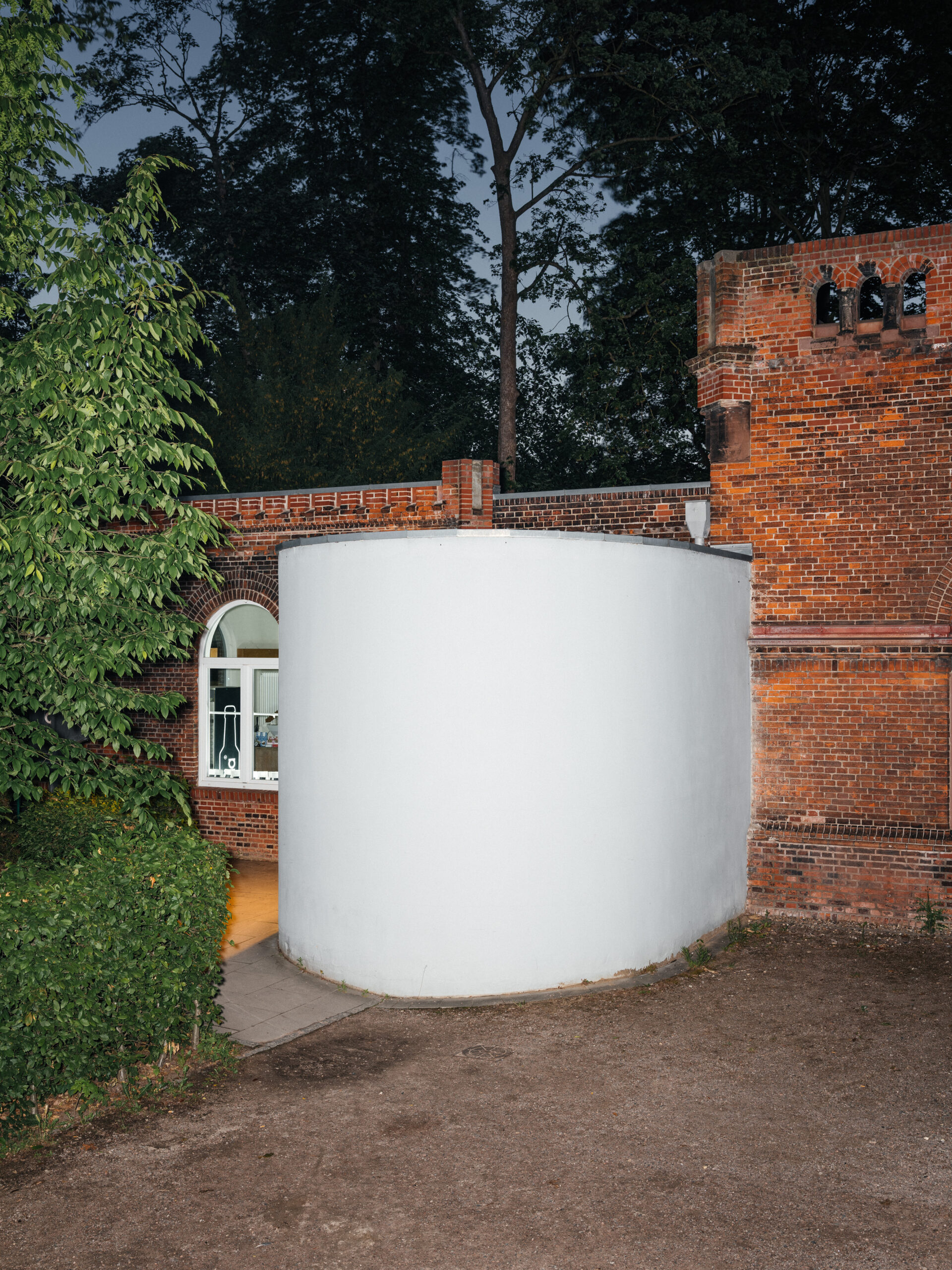 ein Backsteinbau mit einem großen, weißen Anbau